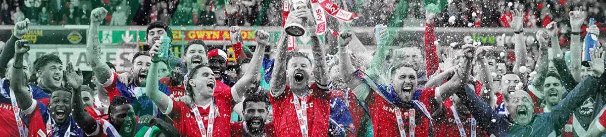 Wrexham players celebrate with trophy after securing a major football victory