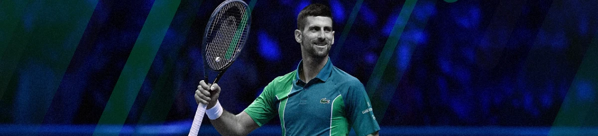 Novak Djokovic smiling while holding a tennis racket on court