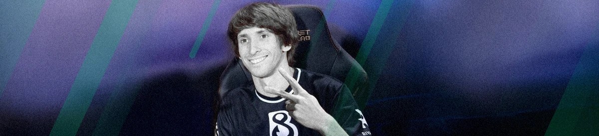 Dendi smiling and flashing a peace sign while seated in a gaming chair, symbolizing his success in esports