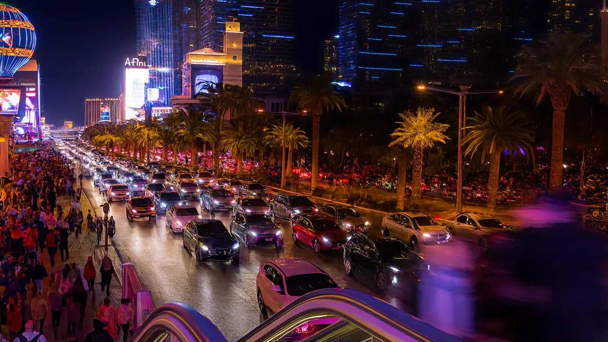 Night traffic and crowds along the Las Vegas Strip under bright neon lights
